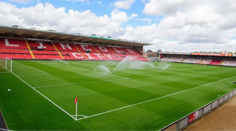 Hình ảnh bên trong sân vận động Sincil Bank nhìn từ khán đài, tập trung vào mặt sân cỏ xanh mướt