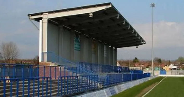 Khu vực khán đài đứng (terraces) tại Tameside Stadium, nơi người hâm mộ Curzon Ashton cổ vũ nhiệt tình