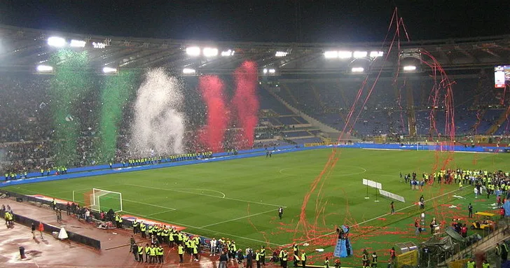 Khung cảnh bên trong sân vận động Stadio Olimpico trước trận đấu, nổi bật khán đài và mặt cỏ