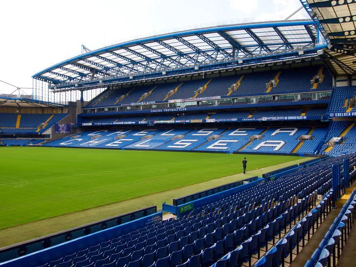 Khung cảnh bên trong sân vận động Stamford Bridge nhìn từ khán đài, thể hiện sân cỏ và các hàng ghế