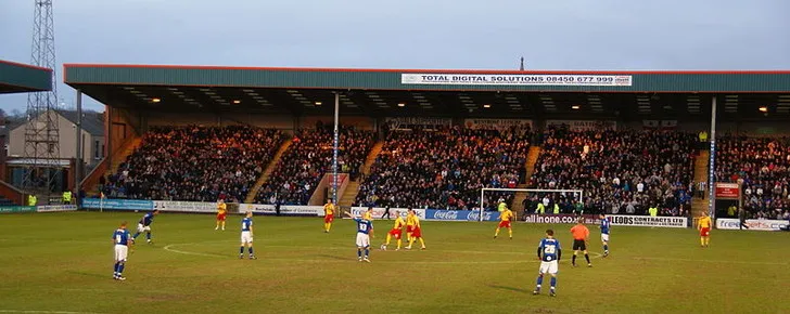 Trận đấu giữa Rochdale và Darlington đang diễn ra trên sân Spotland, cho thấy không khí thi đấu sôi động